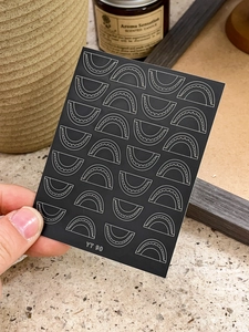 Detail of YT90 nail art sticker featuring white scalloped wave patterns on black base