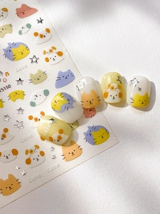 Close-up of cute cartoon cat and star nail stickers applied on artificial tips