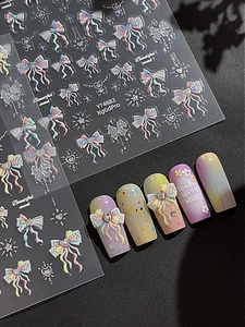 Macro shot of 3D bow and heart nail art stickers with laser glitter effect and pearls
