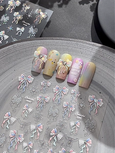 Macro detail of glittery bow and heart nail art stickers with 3D embossed texture