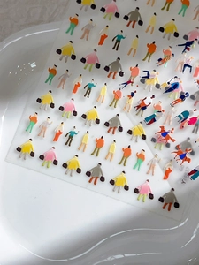 Makro-Detail von bunten Gelee-Cartoon-Nagelstickern auf einer weißen Keramikschale
