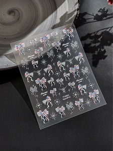 Detailed view of 3D embossed bow and star nail art stickers with glitter finish