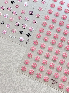 Close-up of 3D embossed cat paw nail stickers with textured details and pearl finish