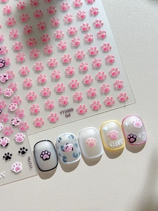 Macro shot of 3D embossed cat paw nail stickers with pink and leopard patterns