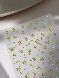 Detailed macro view of laser coconut tree and bird motifs on tropical nail art stickers