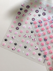 Macro detail of 3D embossed cat claw nail art stickers with relief texture and motifs