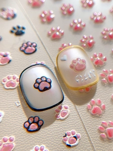 Detailed macro view of 3D embossed cat paw nail art stickers with pearlescent finish