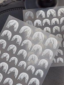 Macro detail of 3D embossed white lace nail art stickers with elegant floral textures