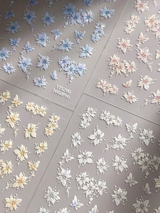 Macro shot of 3D embossed floral and butterfly nail stickers with iridescent glitter