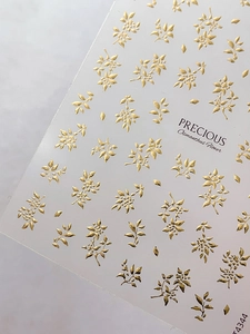 Detail von gold geprägten Osmanthus-Blumen-Nagelstickern mit metallischem Glanz