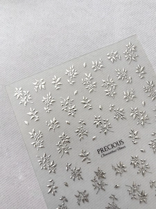 Makroaufnahme der 3D-geprägten Silber-Osmanthus-Blumen-Nagelsticker auf Klarsichtfolie