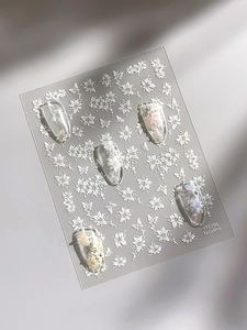 Detail of 5D white floral nail art stickers with butterfly patterns on transparent tips