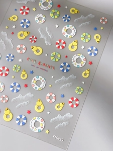 Vista macro di adesivi per unghie con rilievo 3D e motivi colorati di ciambelle estive