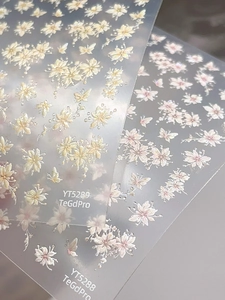 Detail of floral and butterfly embossed nail stickers with pearlescent shell finish