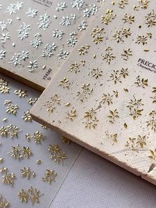 Detail von 3D-geprägten silbernen und goldenen Osmanthus-Blumen-Nagelstickern im Detail