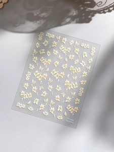 Detailed macro view of 3D embossed floral nail stickers and butterflies on PET backing