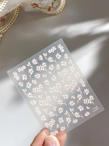 Detailed view of floral nail stickers with pink butterfly patterns and shell luster finish