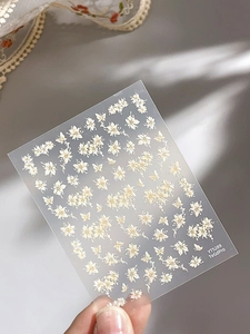 Close-up of YT5289 nail stickers with white flowers and gold edges on hands