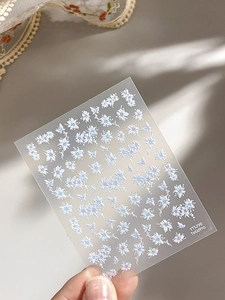 Detail of floral nail art stickers with light blue flowers and butterflies on a sheet
