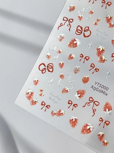 Macro view of 3D embossed strawberry and red bow nail art stickers with silver glitter