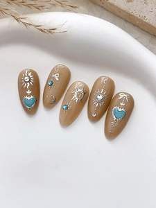 Détail macro de stickers ongles lune et étoiles avec reliefs argentés et strass bleus