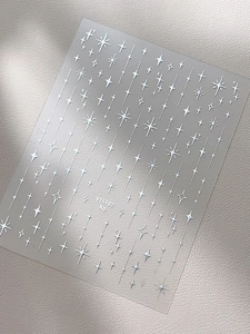 Gros plan d'autocollants pour ongles étoiles argentées avec motifs scintillants sur cuir