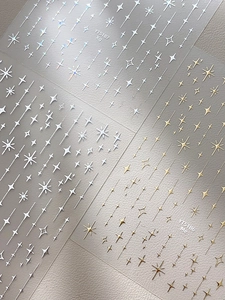 Vue détaillée d'autocollants pour ongles étoiles argentées et dorées aux motifs métalliques
