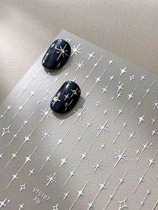 Autocollants à ongles étoiles argentées montrant des motifs brillants sur manucure