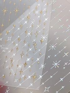 Détail macro d'autocollants holographiques pour ongles avec motifs d'étoiles argentées