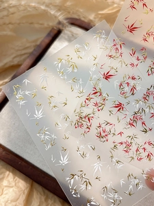 Macro detail of elegant bamboo nail art stickers with gold and red leaf patterns