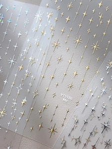 Gros plan de stickers à ongles étoiles dorées et argentées aux motifs holographiques