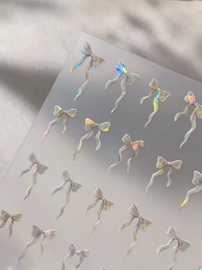 Vue macro d'autocollants 3D pour ongles en forme de nœud en résine irisée chatoyante