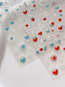 Détail de stickers nail art lune et étoiles avec nœuds dorés et motifs de cœurs
