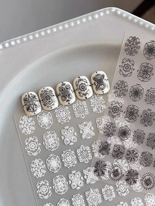 Detailed view of bohemian mandala nail stickers with white and black floral patterns