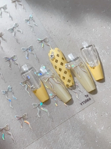 Détail des stickers YT5066 avec nœuds argentés, perles et faux ongles jaunes