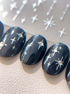 Macro de stickers à ongles noirs brillants avec étoiles argentées et strass brillants