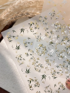 Close-up of golden bamboo leaf nail art stickers featuring Chinese aesthetic design