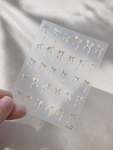 Gros plan d'autocollants pour ongles nœuds irisés avec effet laser et référence YT5066