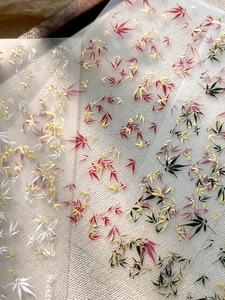 Detailed view of bamboo leaf nail stickers in gold and silver on natural canvas