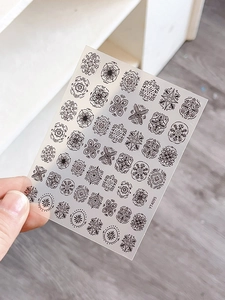 Detailed view of black mandala style nail stickers featuring intricate geometric patterns