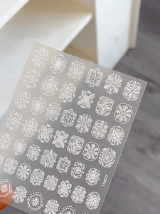 Macro shot of white embossed bohemian mandala nail stickers with 3D texture details