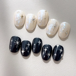 Faux ongles élégants à motif d'étoiles noir et blanc perle avec détails pailletés argent