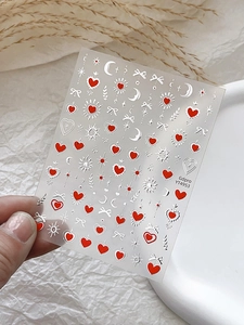 Détail de stickers pour ongles translucides avec cœurs rouges, étoiles et lunes
