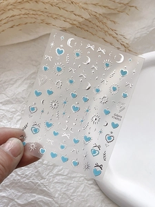 Gros plan d'autocollants pour ongles avec cœurs bleus et étoiles argentées en relief