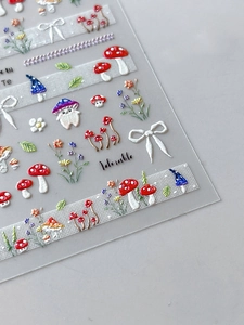 Macro view of 3D embossed mushroom and floral nail decals with matte texture