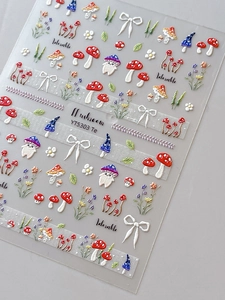 Macro detail of 5D embossed mushroom nail stickers with 3D floral and bow patterns