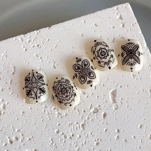Bohemian embossed nail stickers with black mandala patterns on cream-colored base