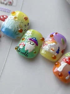 Close-up of short round custom press-on nails with 3D amber resin droplets and mushroom art