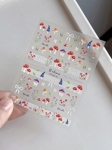Detailed view of 5D embossed mushroom and bow nail art stickers with textured finish