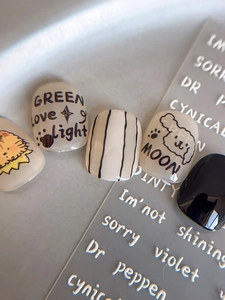Gros plan de stickers à ongles minimalistes avec animaux dessinés et texte anglais